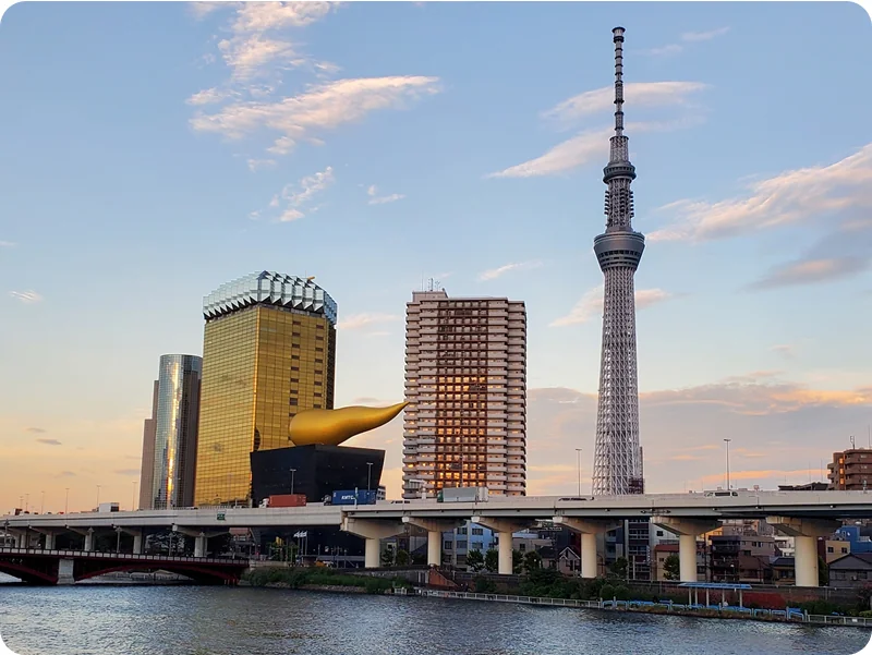 隅田川越しに望む夕日に照らされたアサヒ本社とスカイツリー