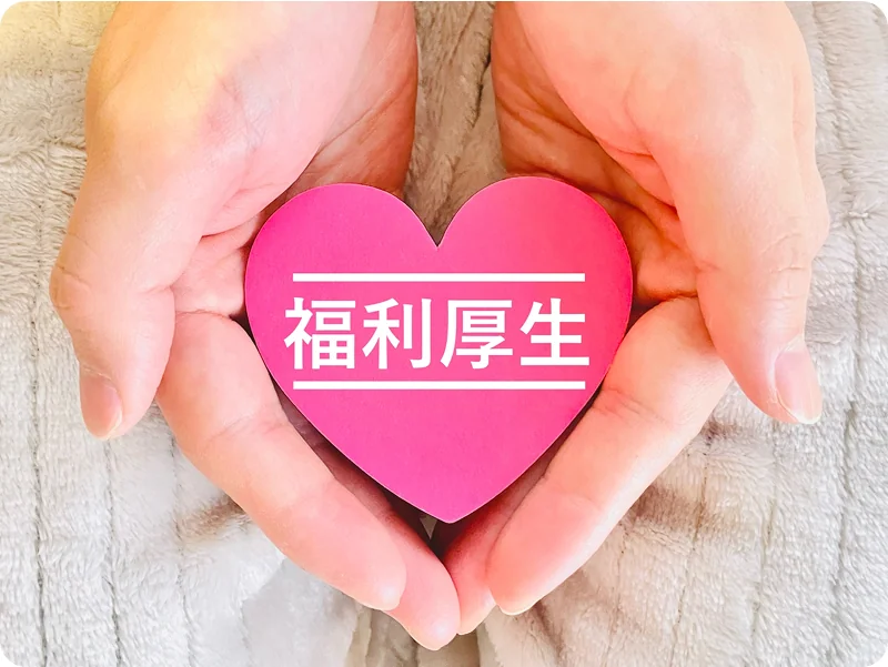 手のひらに乗る福利厚生と書かれたハート型の積み木