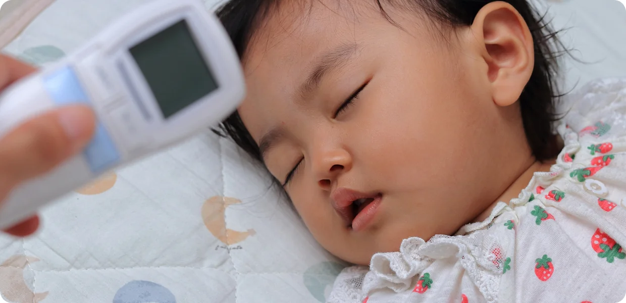 子供の熱を計る登録ヘルパーとして働く女性
